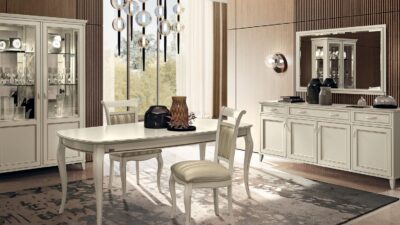 Ivory lacquer Giotto dining set with an oval table, upholstered chairs and a glass-front display cabinet.