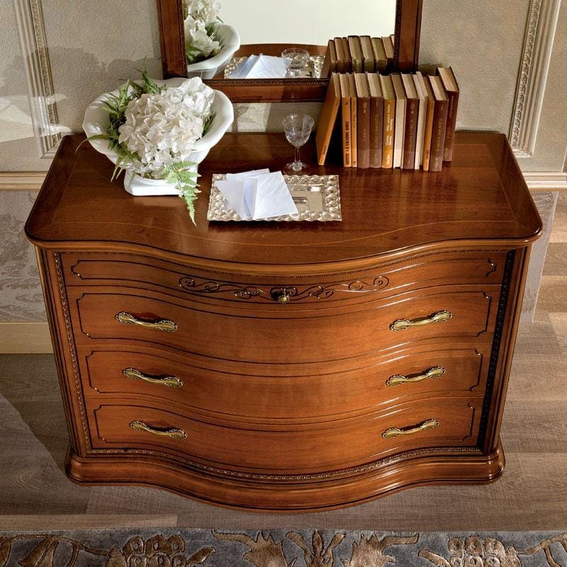 Close-up of the bowed walnut dresser with brass bail handles from the Torriani bedroom collection.